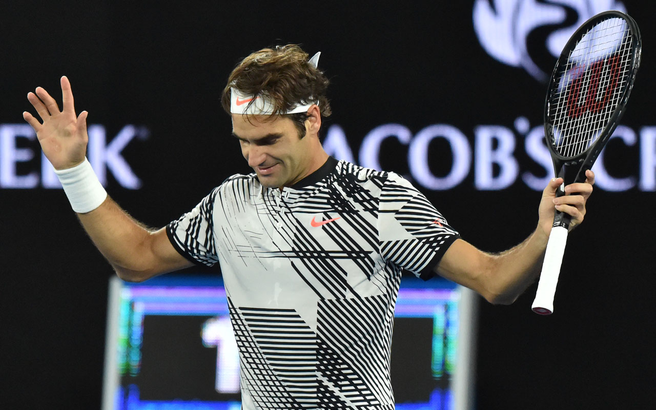 Switzerland's Roger Federer celebrates his victory against Switzerland's Stanislas Wawrinka during their men's singles semi-final match on day 11 of the Australian Open tennis tournament in Melbourne on January 26, 2017. / AFP PHOTO / PETER PARKS / 