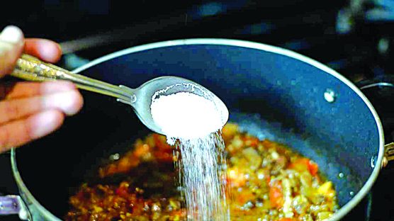 ADDING EXTRA SALT TO FOODS: Experts have warned that a person who eats excessive amounts of salt may be at risk of: enlarged heart muscles, headaches, obesity, heart attack, kidney disease, osteoporosis, stroke, heart failure, high blood pressure, kidney stones and gastric/stomach cancer.