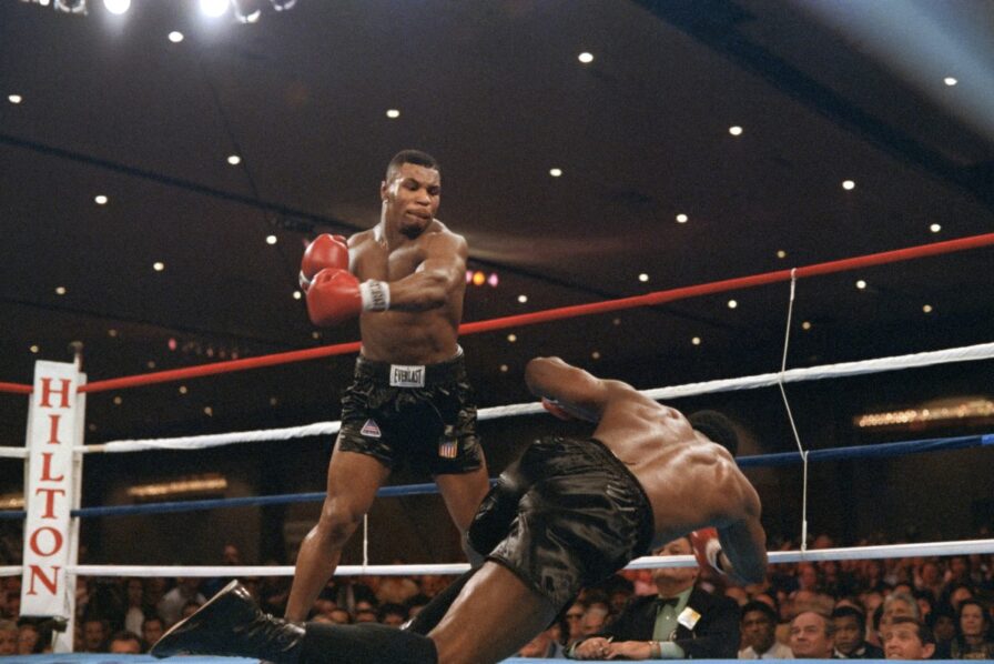 Heavyweight champion Trevor Berbick goes down after a hard left from challenger Mike Tyson in the 2nd round of their scheduled 12 round WBC title bout at the Las Vegas Convention Center on November 22, 1986. - Tyson won the fight by knockout in 2:35 of the second round to become the youngest heavyweight champion of the world in history at 20. Both Tyson Fury and Usyk aim to join this elite set on Saturday.(Photo by Carlos SCHIEBECK / AFP)