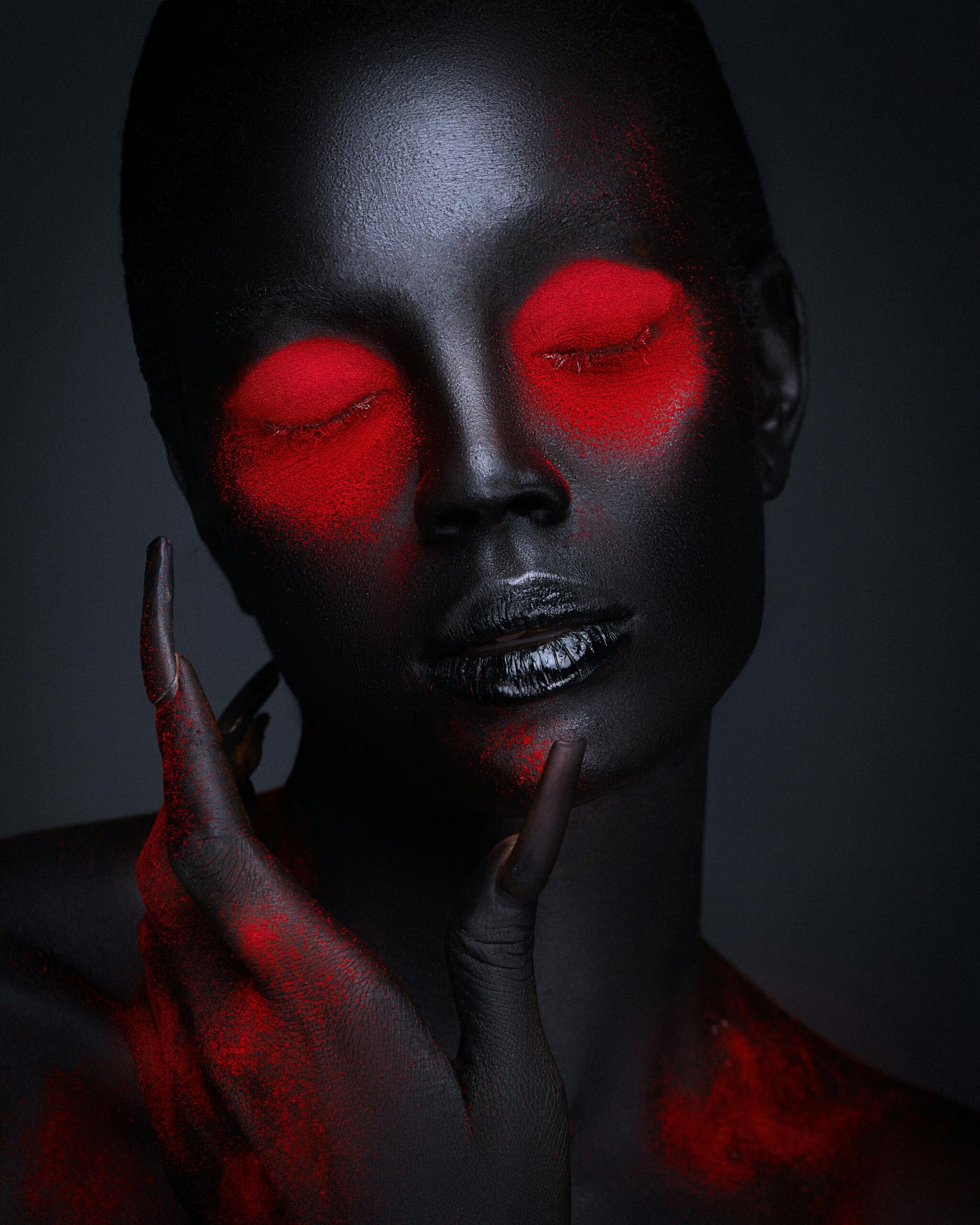  Very dark-skinned woman on artistic red painting with black lipstick and long nails