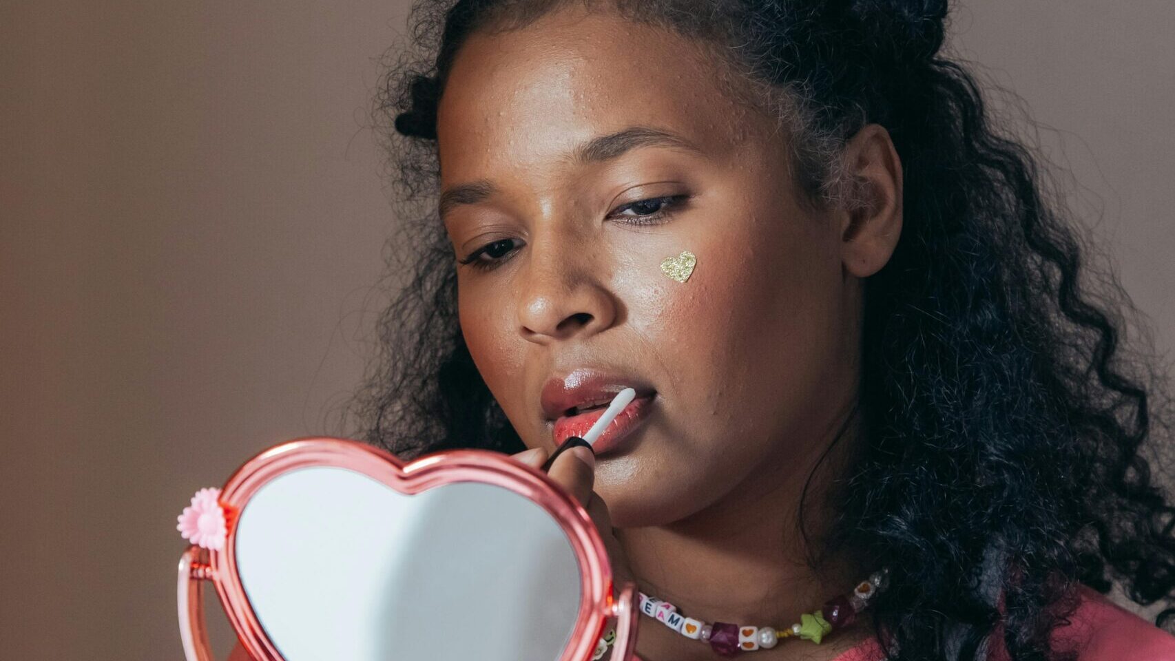 Woman applying makeup with a mirror