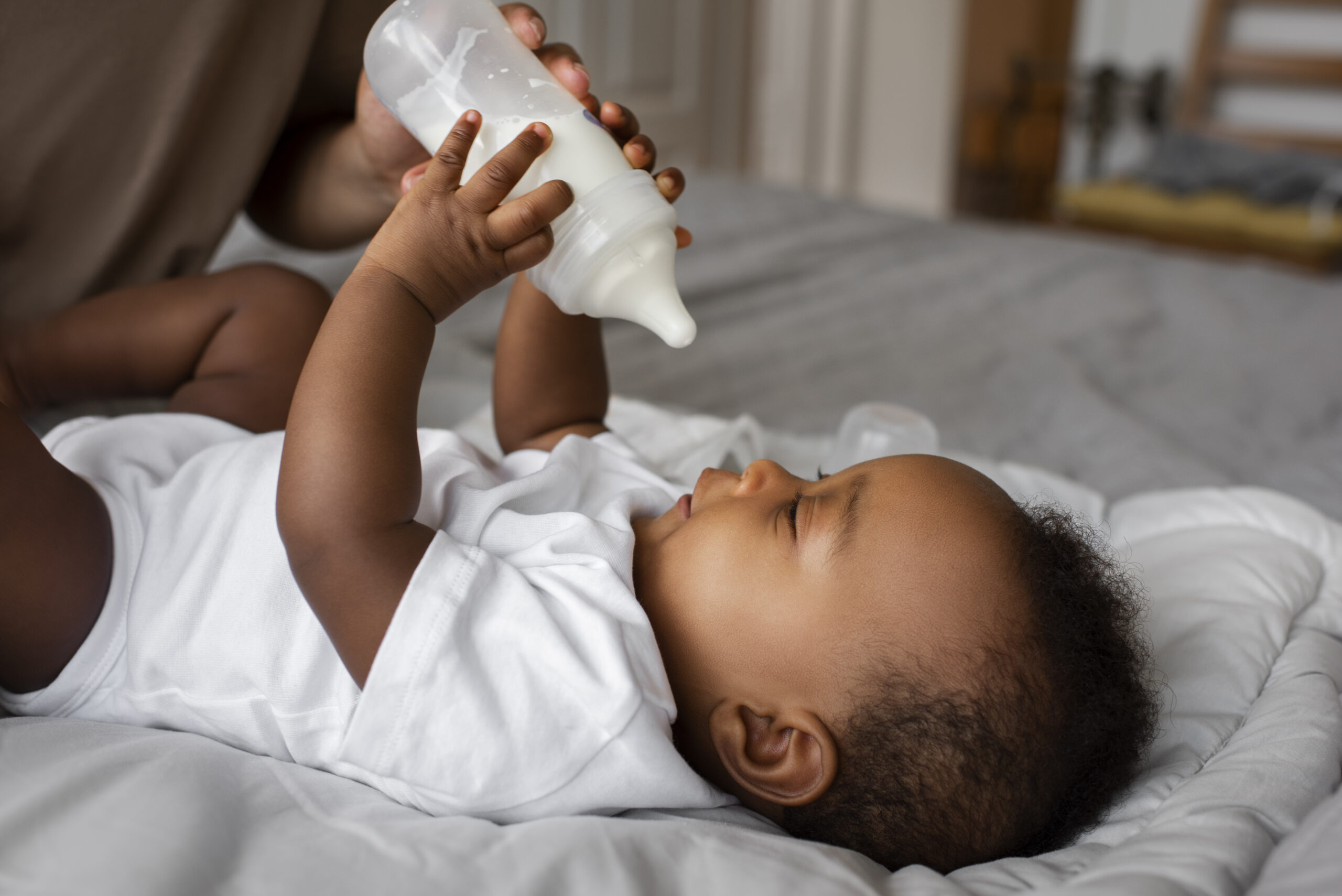 Photo of parent bottle-feeding their baby