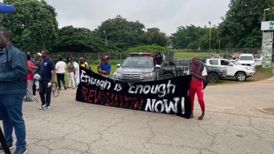 Protesters in Abuja holding a banner with inscription: "Enough is enough, revolution now."