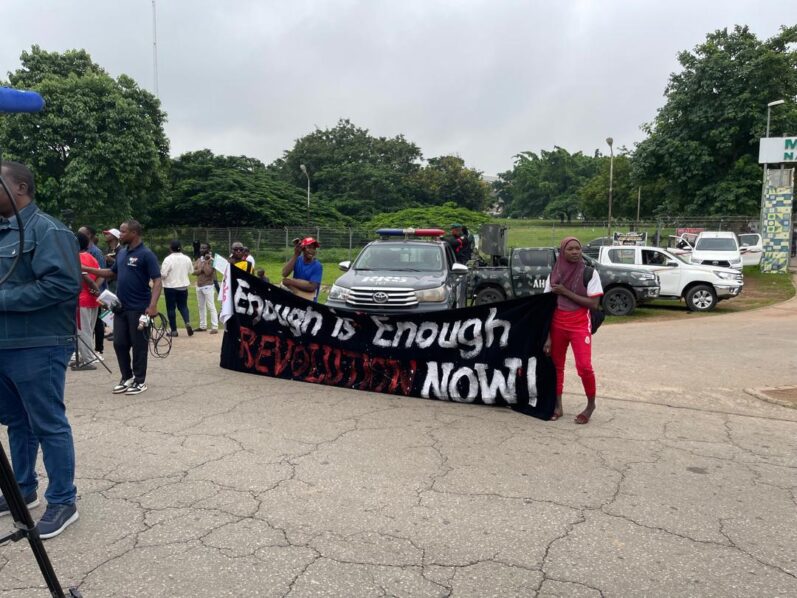 Protesters in Abuja holding a banner with inscription: "Enough is enough, revolution now."