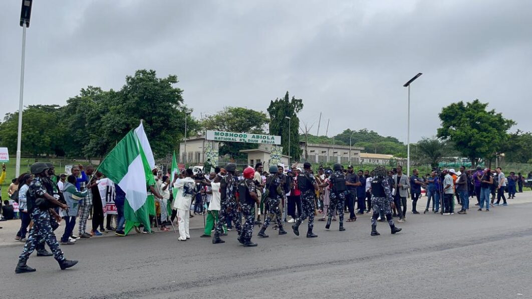 The number of security forces at the National Stadium in Abuja with combined 20 Toyota Hilux and three ambulances is competing with the number of protesters