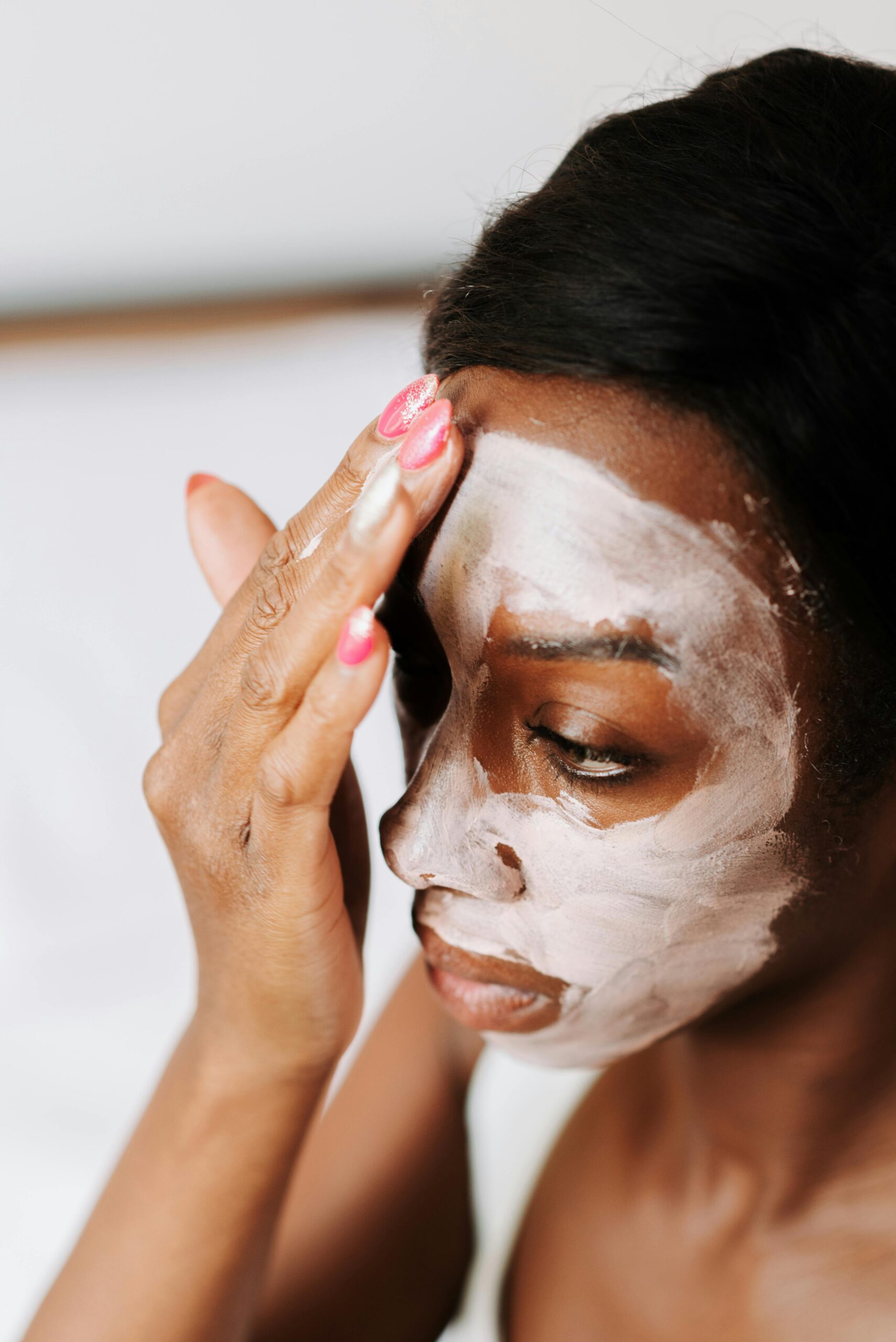 Woman applying cream on her face 