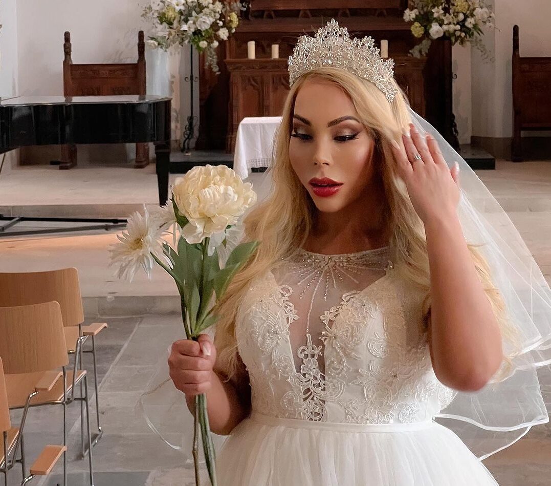 Sullen Carey in a wedding dress, holding a bouquet