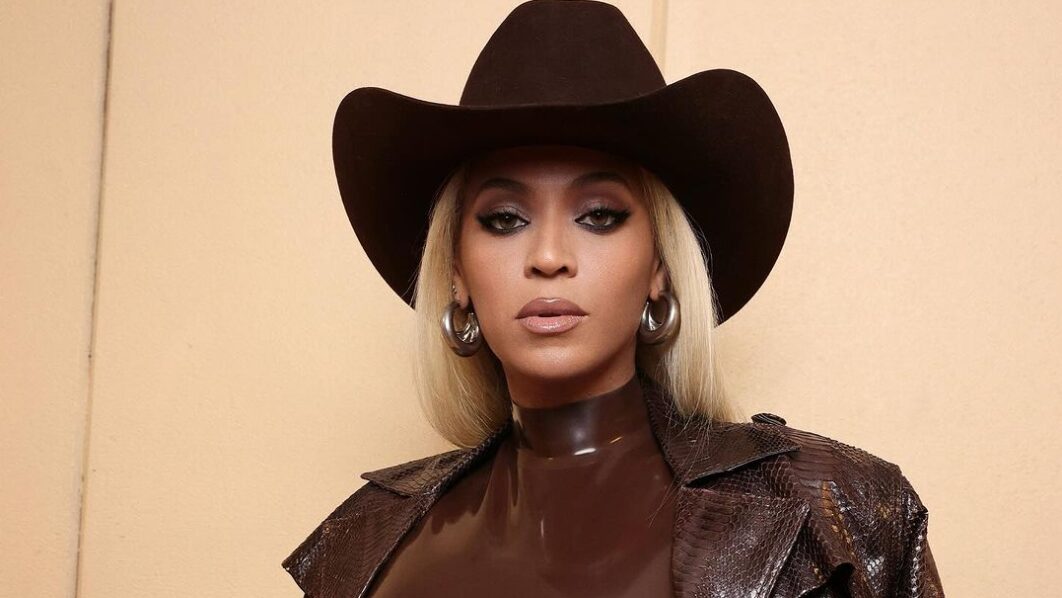 Beyonce on a coffee brown cowboy hat, a jacket and a gown