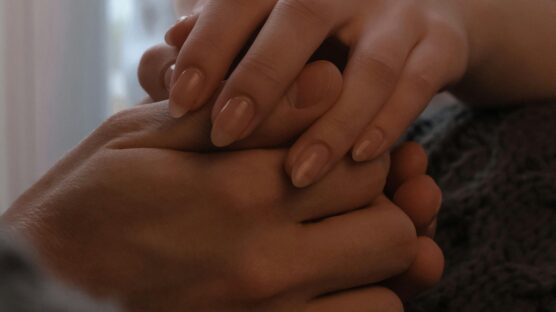 Couple holding hands in an intimate way.