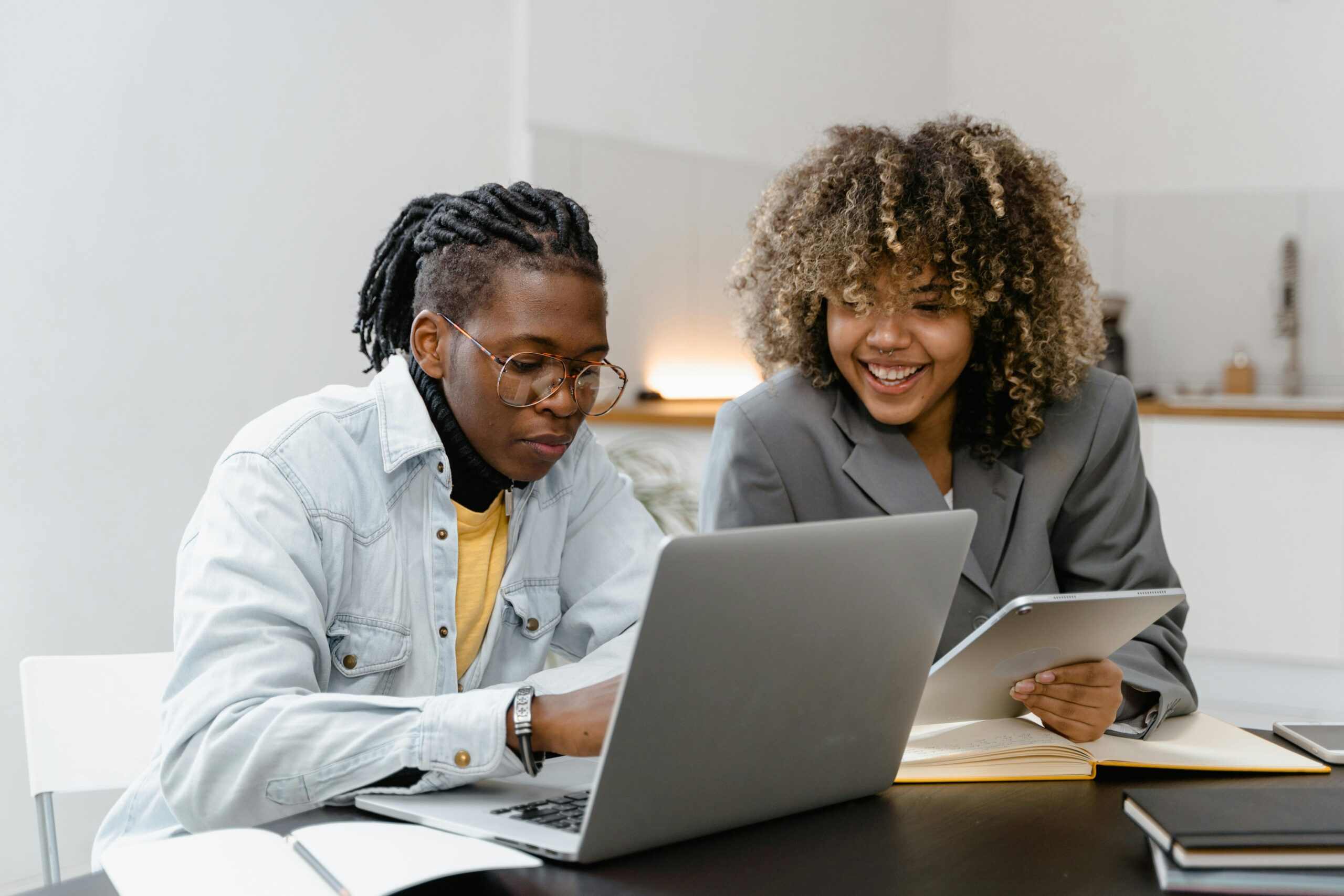 A man and a woman sitting near a table with a laptop at their front