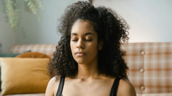 A woman on a black top practicing mindful breathing