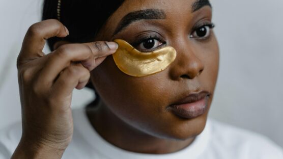 A young woman applying eye product on her eyebag