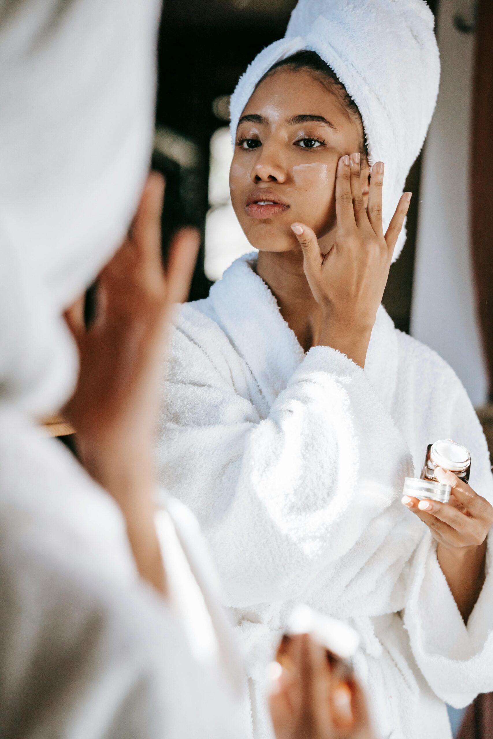 Lady applying skincare product on her face