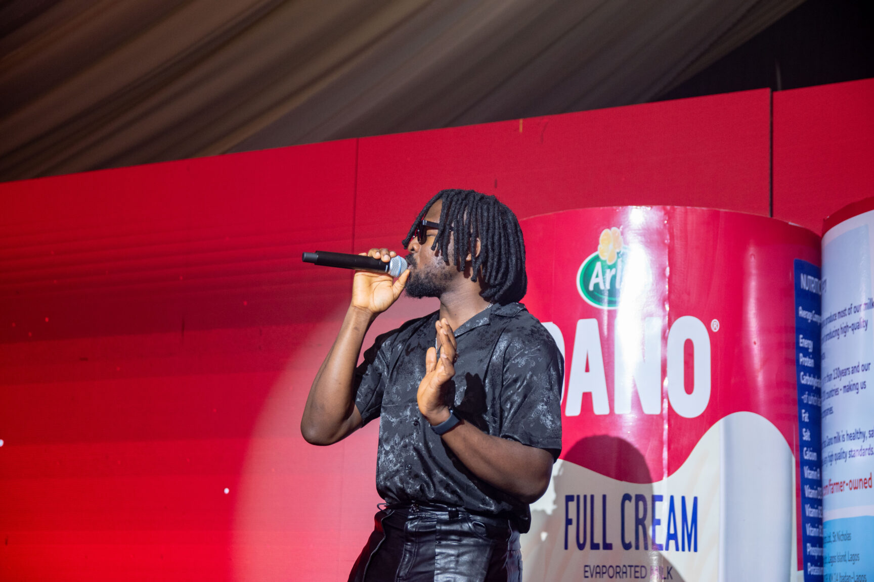 Johnny Drille performing at the Dano launch event