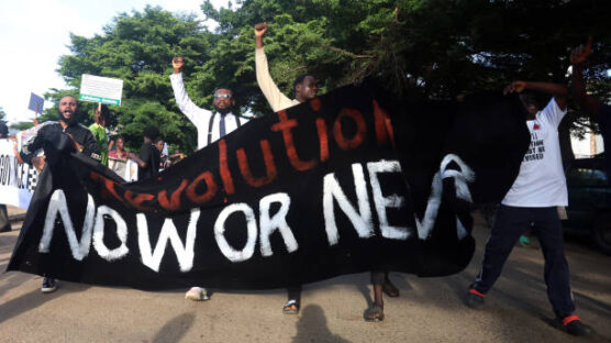 Protesters carry a large banner reading "Revolution now or never" during the "Fearless In October" protest over bad governance in Abuja, Nigeria on October 1, 2024.