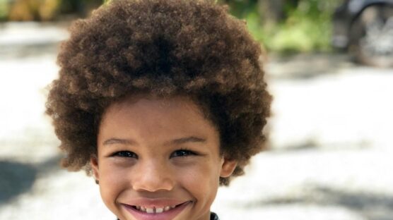 A kid standing and smiling