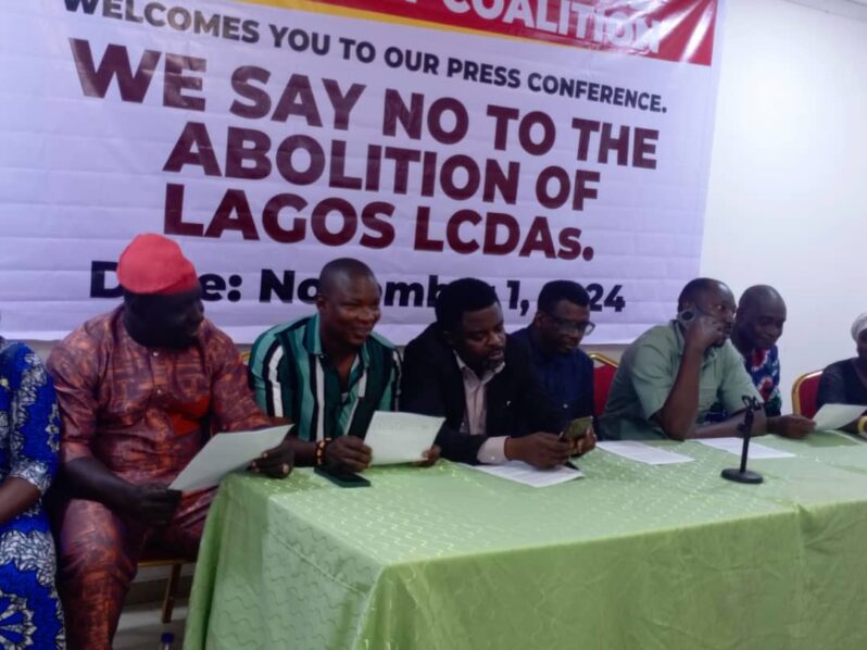 Civil society groups and concerned Lagosians, led by Comrade Sina Loremikan, protest a Lagos Assembly bill proposing the replacement of LCDAs with Area Administrative Councils, citing threats to local governance and community development.