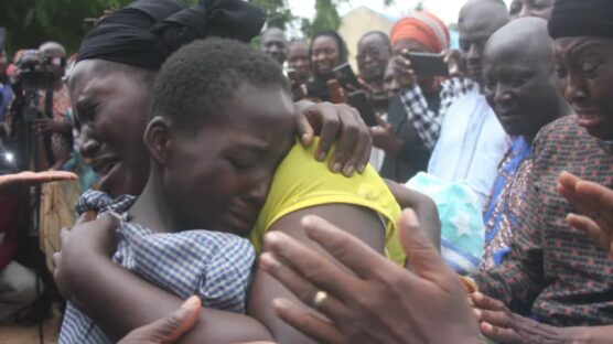 A mother hugs her daughter on July 25, 2021, after she was released together with 27 other students of the Bethel Baptist High School in Kadune state, Nigeria [AFP]