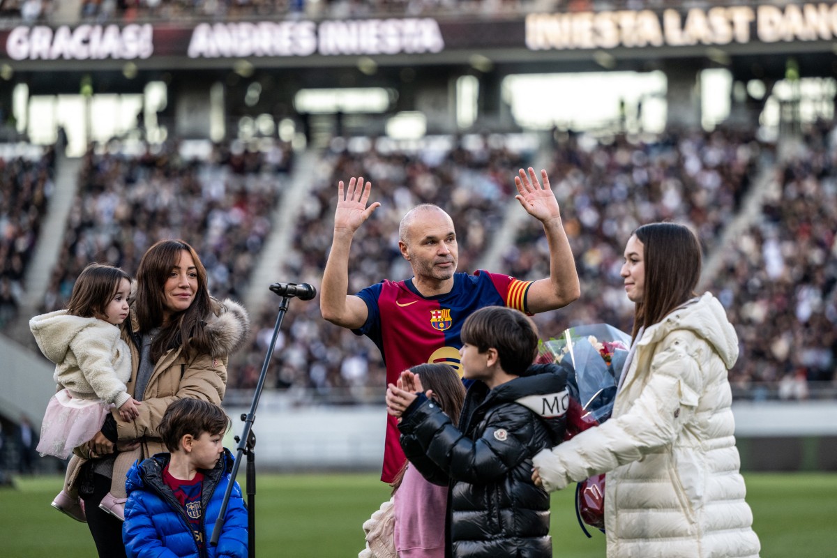 Spanish football legend Andres Iniesta (C) gestures as he is joined by his wife Anna Ortiz and his five children during his retirement ceremony after the exhibition football match between former Barcelona and Real Madrid players -- Barca Legends and Real Madrid Leyendas -- at Ajinomoto Stadium in Tokyo on December 15, 2024. - (Photo by Philip FONG / AFP)